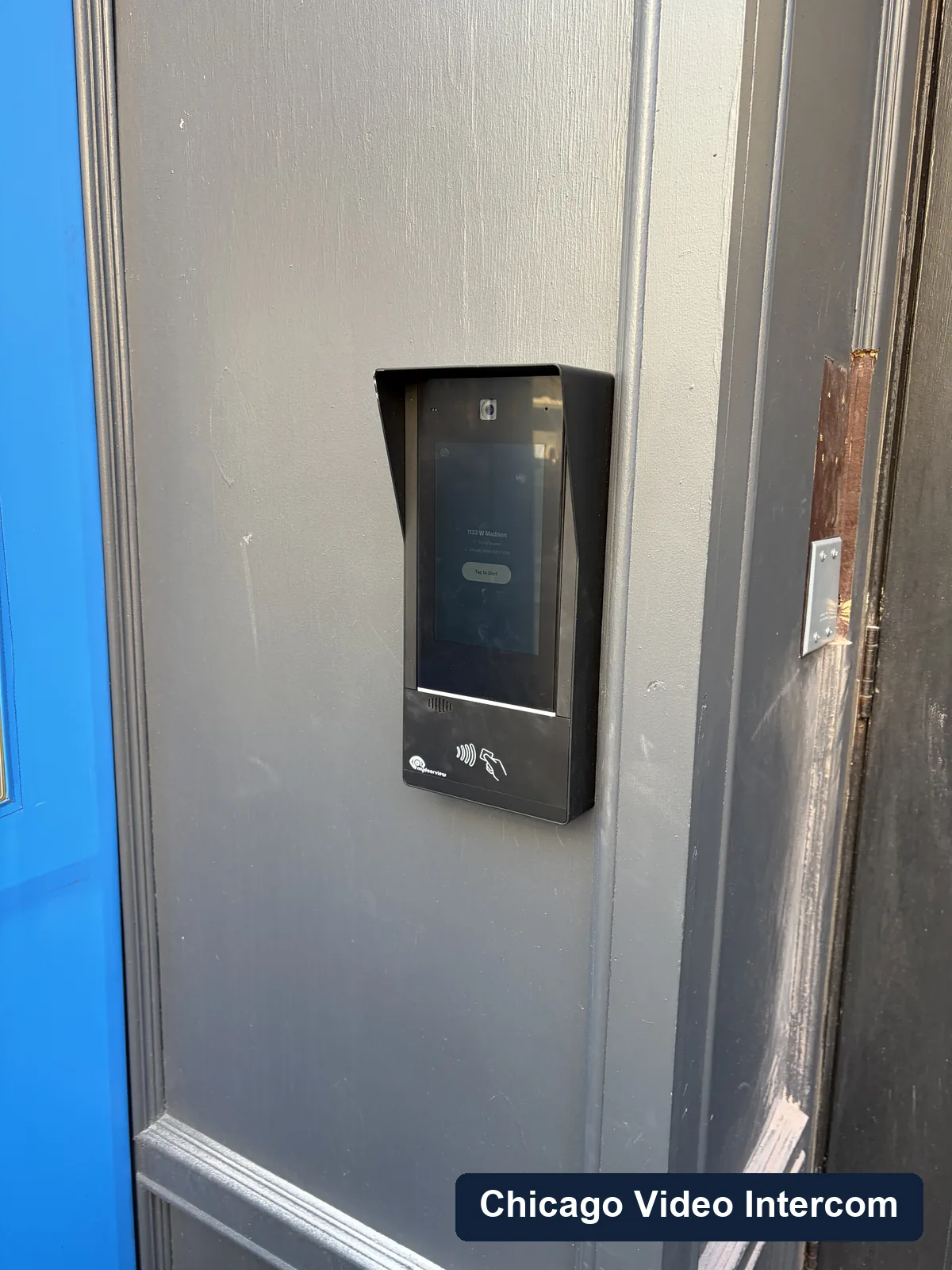 Black exterior video intercom panel mounted near a Chicago entry door