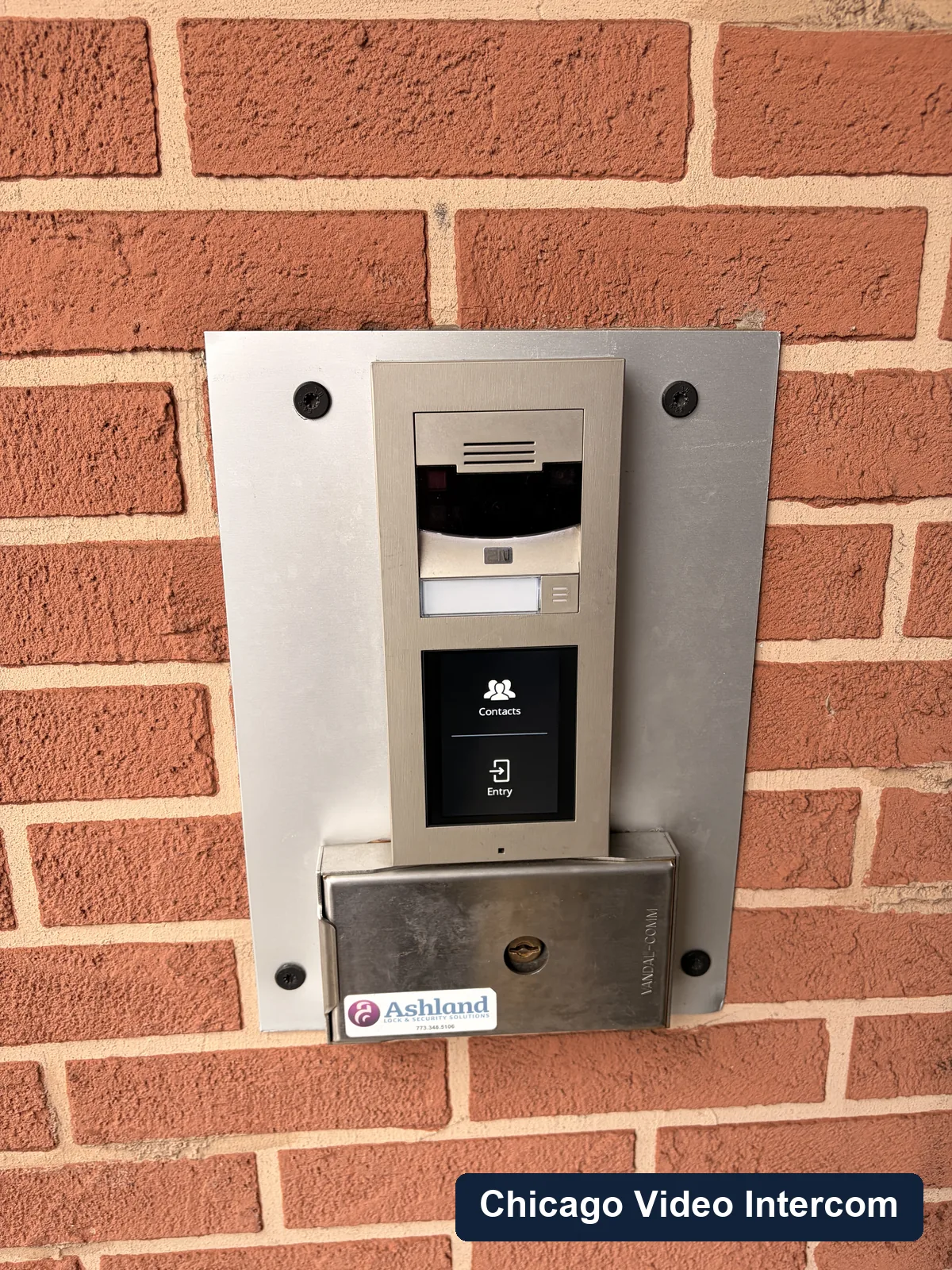 Video entry panel mounted beside a brick Chicago building door