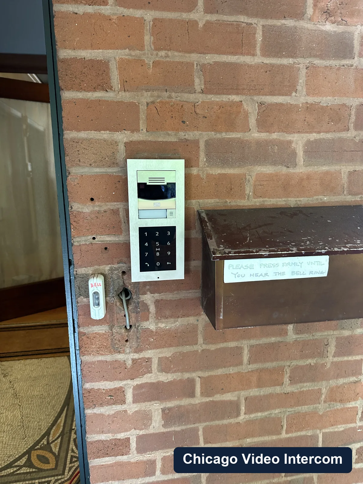 Keypad video intercom panel mounted on a brick Chicago entry
