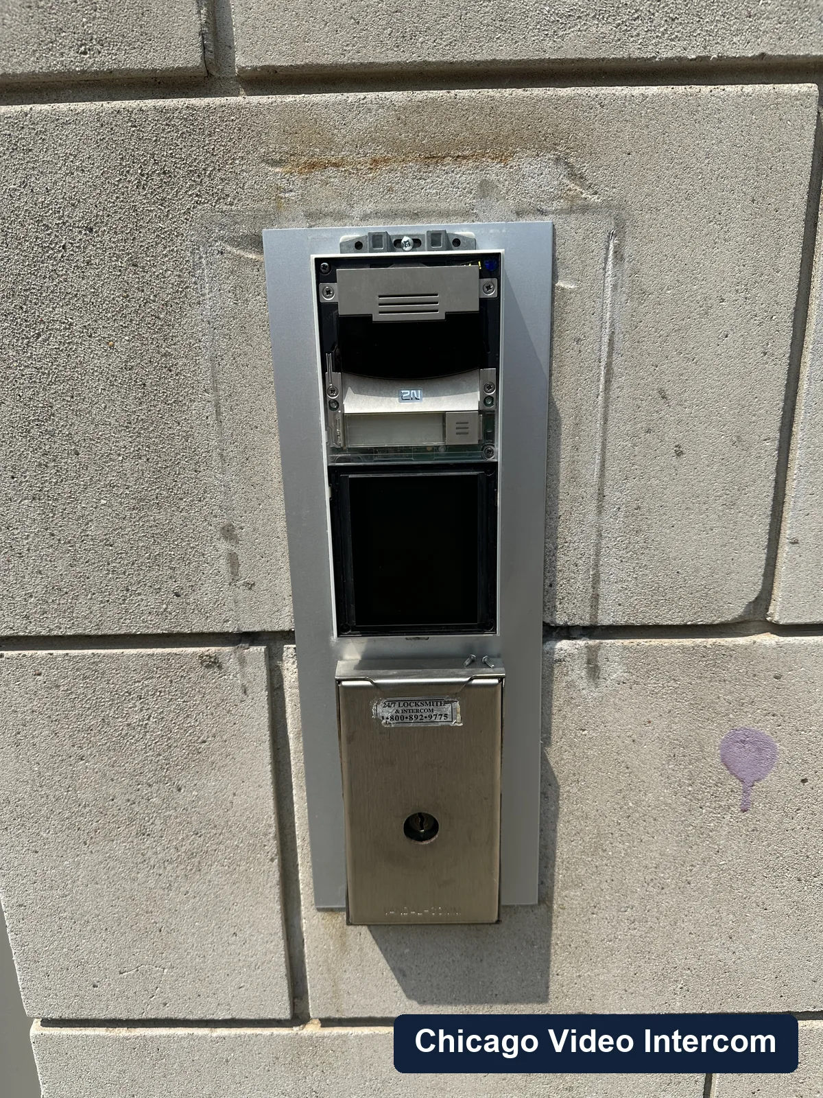 Video intercom panel mounted at a stone Chicago building entry
