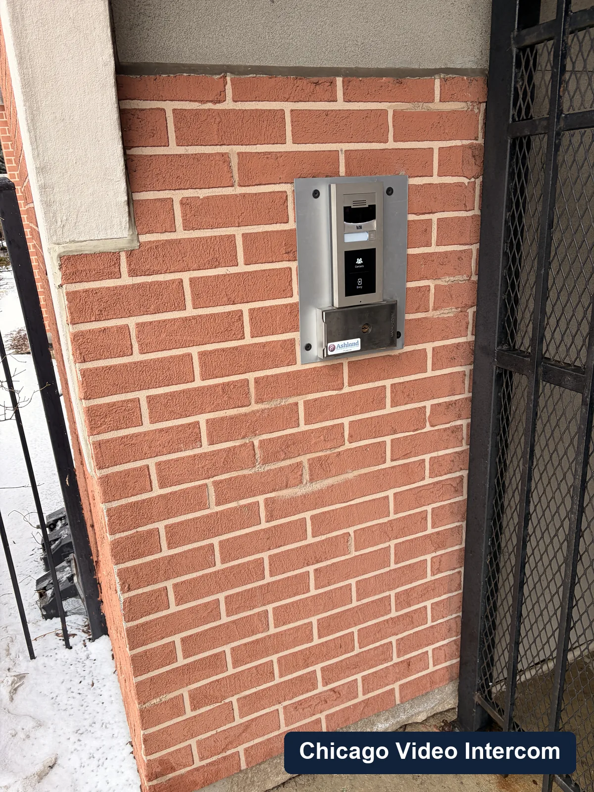 Close-up of video entry panel hardware mounted on brick