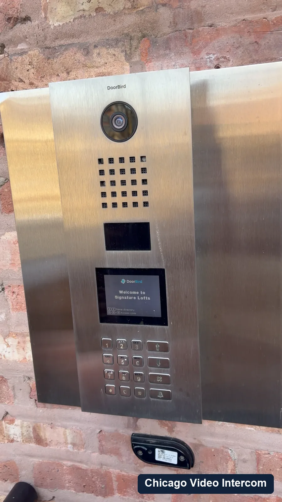 DoorBird video intercom panel mounted on a brick Chicago building entry