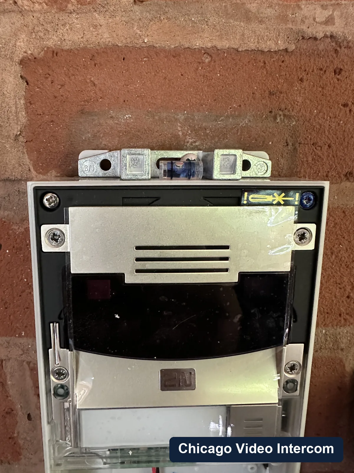 Open video intercom panel on brick during repair in Chicago